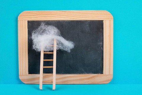 Ladder with a cloud on top, blank chalkboard, blue colored background, copy space, dreaming of