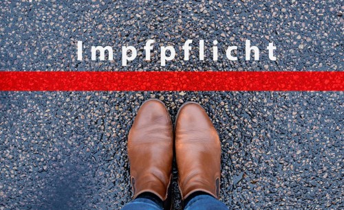 The word mandatory vaccination is standing on the road, german language, compulsary vaccine,