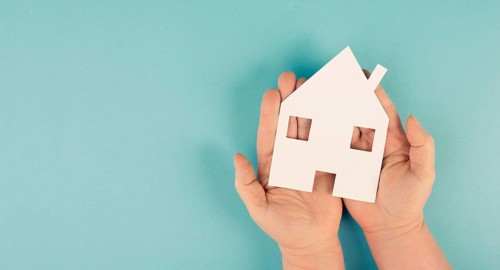 Holding a small paper house in the hands, planing a new home, real estate, owning property