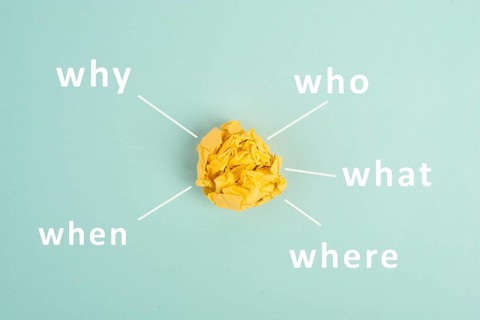 Crumpled up yellow paper on a bluec olored background, brainstorming, new idea, why, what, who