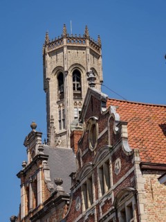 Gothic stone bell tower with ornate details on a sunny day, Bruges, Flanders, Belgium, Europe