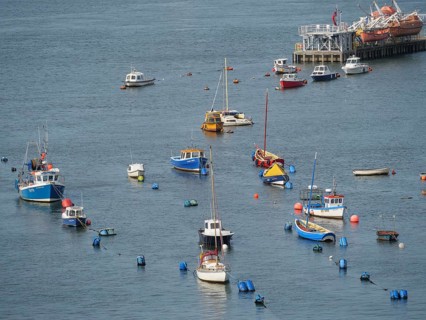 Several boats and moorings in the water with a calm clear sky in the background, newcastle upon