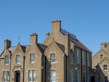 Historic brick buildings with chimneys and windows, shot under a clear blue sky, lerwick,