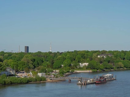 River landscape with a bridge and green bank areas, urban surroundings in the background, Elbe,