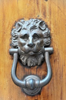Siena, Tuscany, Italy, Europe, A detailed lion's head door knocker on an antique wooden door,