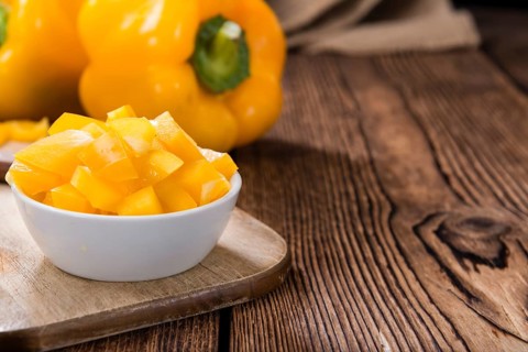 Portion of yellow Peppers (sliced, selective focus) on wooden background