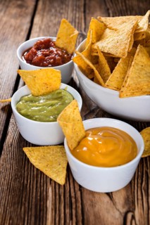 Three different nacho dips (Salsa, Cheese and Guacamole)