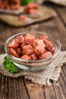German Mettwurst (Chilli flavoured) as close-up shot (selective focus) on wooden background