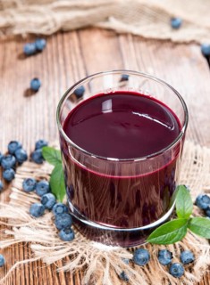 Fresh made Blueberry Juice with some fruits on wooden background