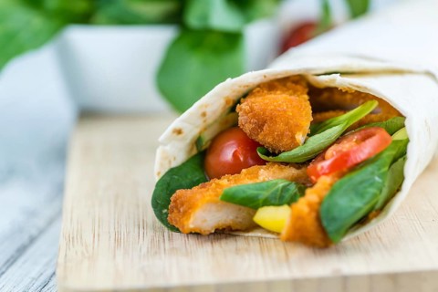 Chicken Wraps on a wooden table as detailed close-up shot (selective focus)