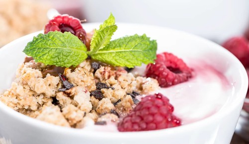 Bowl with fresh made Raspberry Yogurt and some fruits