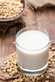 Soy Milk with some Seeds (close-up shot) on wooden background