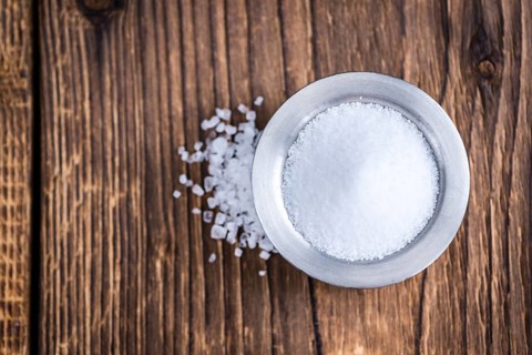 Portion of crushed Salt (close-up shot) on rustic wooden background