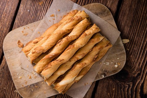 Crispy Pastry Sticks on wooden background (close up shot, selective focus)