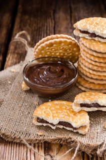 Portion of Chocolate Cream Cookies (on wooden background)