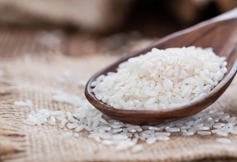 Portion of uncooked Rice on rustic wooden background