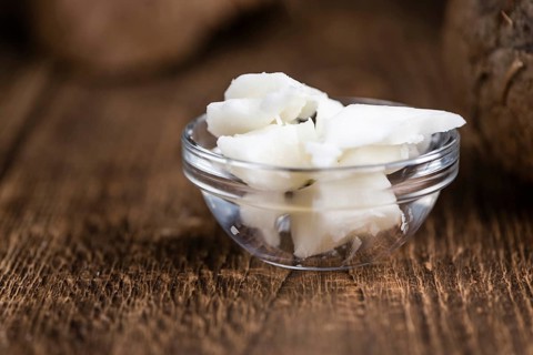 Coconut Oil (selective focus) on an old wooden table (close-up shot)