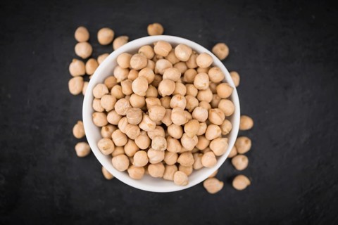 Some dried Chickpeas on a slate slab as detailed close-up shot, selective focus
