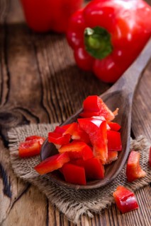 Sliced red Peppers (selective focus) on vintage wooden background