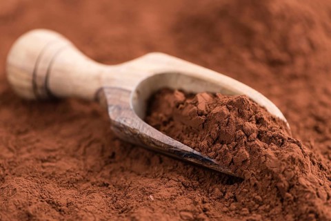 Cocoa powder (selective focus) as detailed close-up shot on wooden background