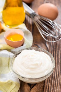 Fresh homemade Mayonnaise on an old wooden table (close-up shot)