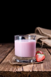 Homemade Strawberry Milk (selective focus) on an old wooden table