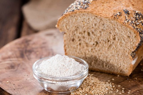 Fresh baked bread with seeds on rustic wooden background