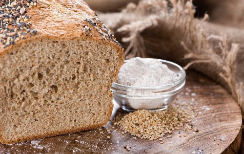 Homemade loaf of bread on dark wooden background