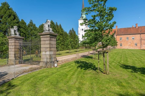 Brahetrolleborg church and castle, castle entrance, lawn, lions with coat of arms, Faborg, Faaborg,