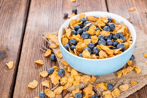 Portion of Cornflakes with fresh Blueberries (close-up shot)