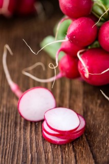 Chopped Radishes (close-up shot) on an old wooden table (selective focus)