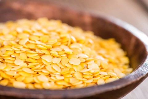Portion of Yellow Lentils on vintage wooden background