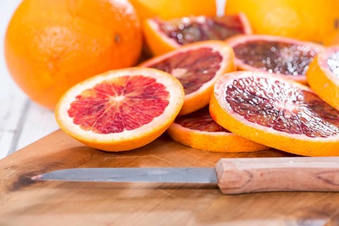 Portion of fresh and juicy Blood Orange on wooden background
