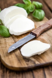 Old wooden table with Mozzarella as detailed close-up shot (selective focus)