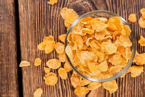 Portion of golden Cornflakes on wooden background (close-up shot)