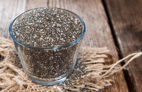 Chia Seeds in a small bowl (on dark wooden background)