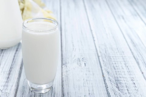 Portion of Milk on wooden background (close-up shot)