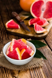 Sliced Grapefruit (close-up shot) on rustic wooden background