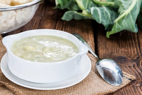 Cauliflower Soup in a small bowl (close-up shot) on wooden background
