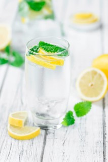 Homemade Lemonade on an wooden table (selective focus) as detailed close-up shot