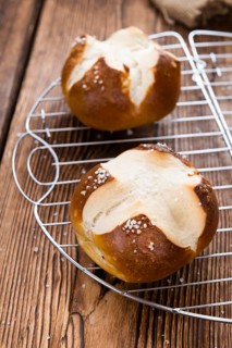 Salty Pretzel Roll (close-up shot) on rustic wooden background