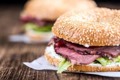Roast Beef Bagel (selective focus) on vintage background (close-up shot)