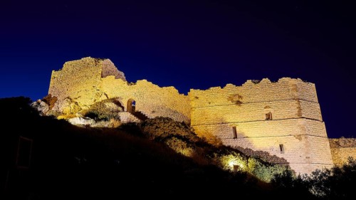 Night shot, A festively illuminated castle rises in the night, its stone walls glowing against the