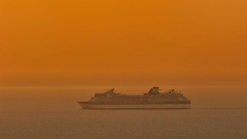 Large cruise ship sails through the calm, orange-coloured sea at sunset, Kritinia Castle, St John's