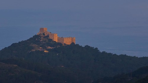 A castle on a hill in the first morning light, surrounded by natural landscape, Kritinia Castle, St