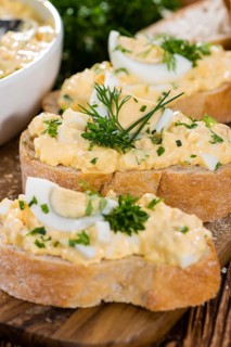 Piece of Bread with fresh homemade Egg Salad (close-up shot)