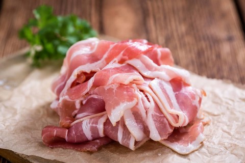 Raw Bacon slices (detailed close-up shot) on vintage wooden background