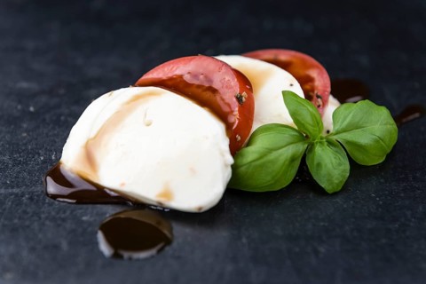 Portion of Mozzarella with Tomatoes (detailed close-up shot, selective focus)