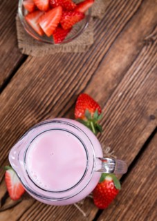 Fresh made Strawberry Milk on an old wooden table (selective focus)