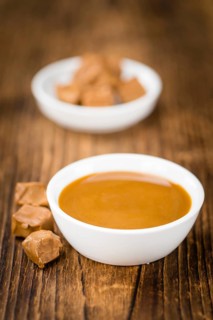 Portion of fresh Caramel Sauce (close-up shot, selective focus)
